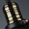 Agda Loft Black English Street Style Pendant Light - A close-up image of a black and brass lamp socket with a screw. The image emphasizes the industrial design with its exposed metal and textured finish.