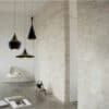 Judit Arabic Inspired Pendant Light - Three black pendant lights hanging from the ceiling in a modern, minimalist interior. The lights have different shapes and sizes, creating a visually interesting display.